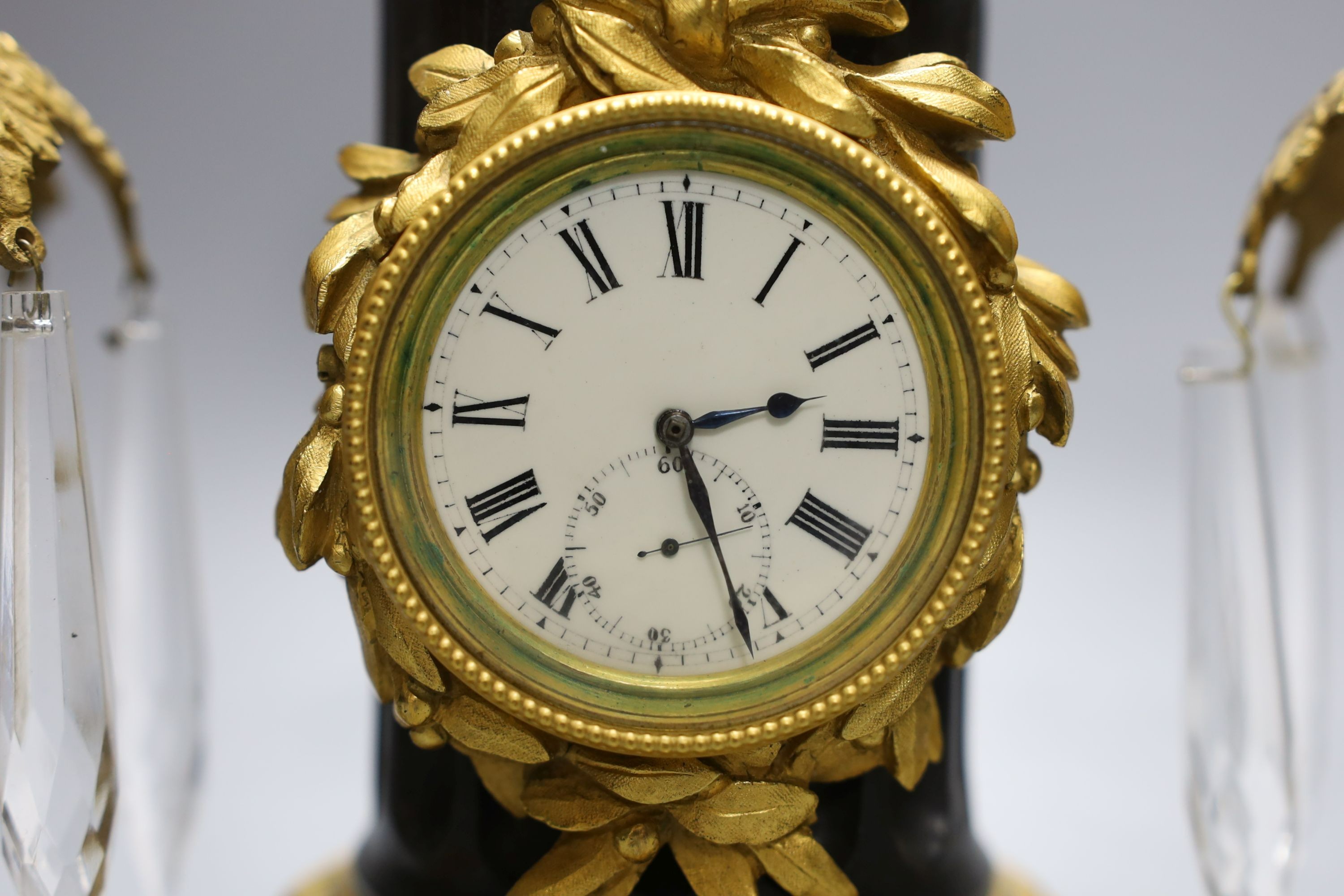 A bronze and ormolu bust mounted pedestal timepiece and a pair of gilt metal lustres 27cm